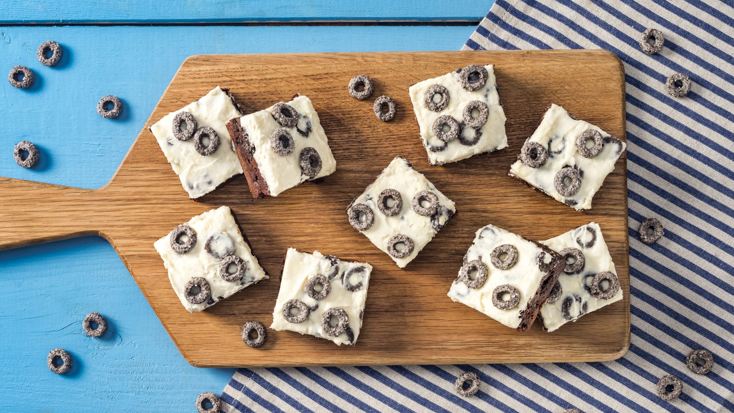 Chocolate Oreo O’s Cookies and Cream Brownies on a wooden cutting board with oreo o's scattered about.