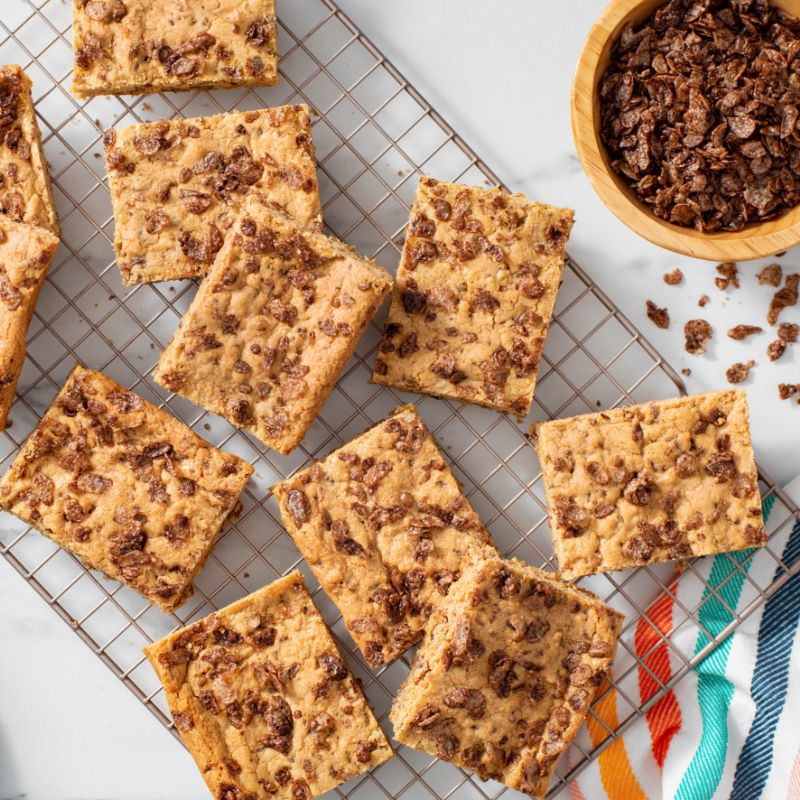 Cocoa Pebbles Blondie squares on a cooling rack.