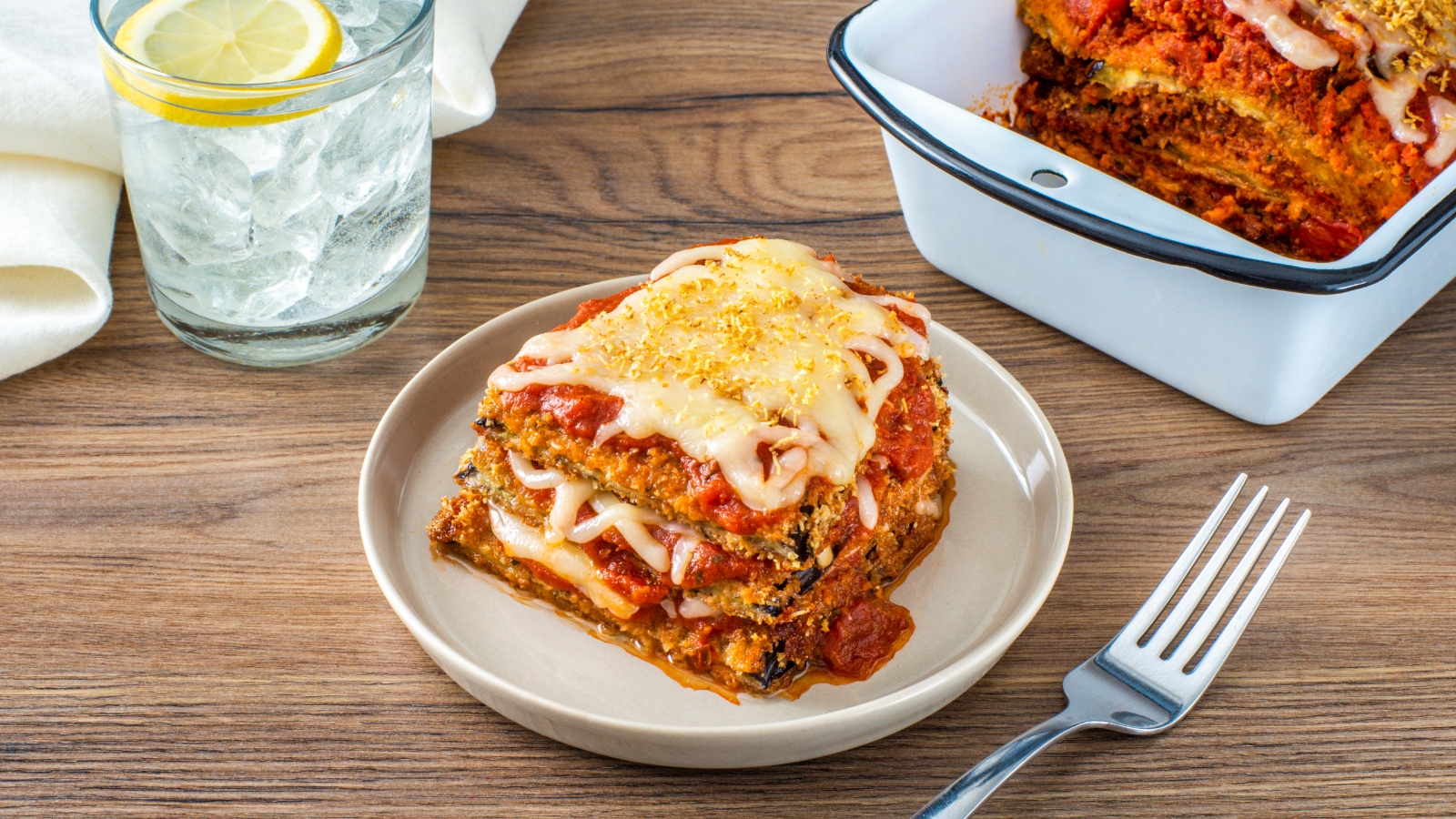 Crispy-Shredded-Wheat-Eggplant-Parmesan Crispy Shredded Wheat Eggplant Parmesan on a plate with a glass of water with a lemon in the background.