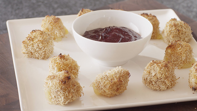 Cheese Croquettes on a white plate with a bowl of Haskap Berry Ketchup in the middle.