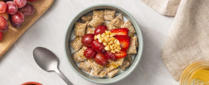 PB and J in a bowl with strawberries on top and a spoon on the side.