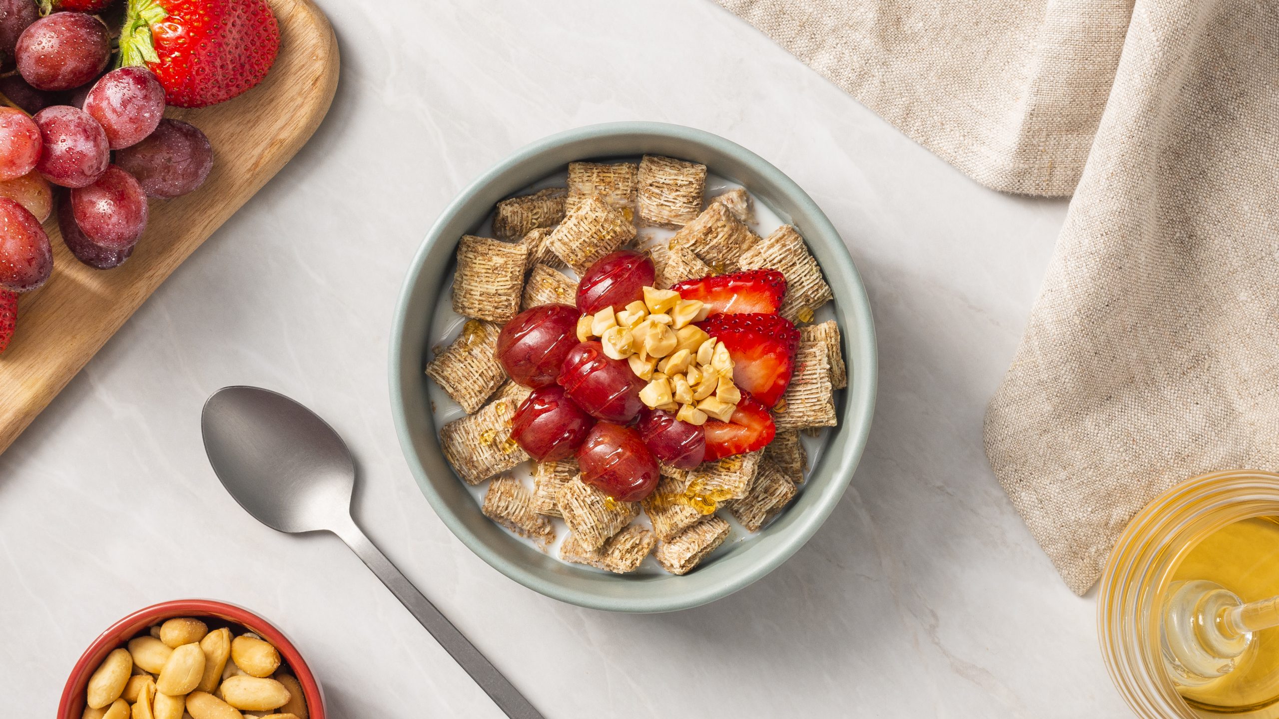 PB and J in a bowl with strawberries on top and a spoon on the side.