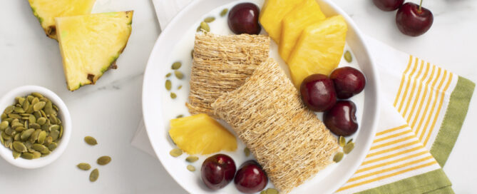 Two Shredded Wheat Biscuits with pineapple slices and cherries.