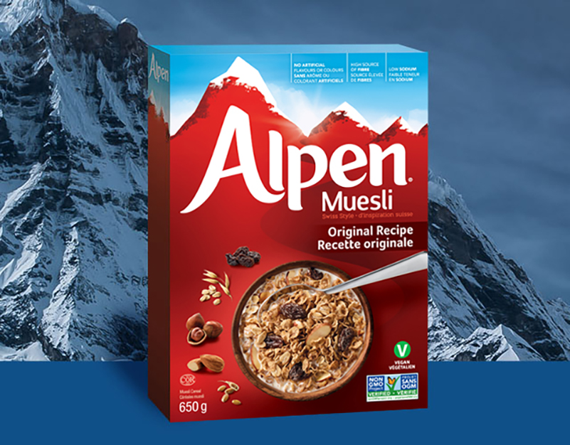 Alpen Muesli - Original Recipe cereal box in front of snow-capped mountains