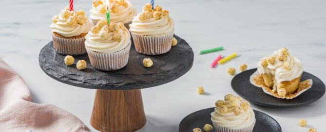 Timbits Birthday cake cereal cupcakes on a black platter and plates with candles.