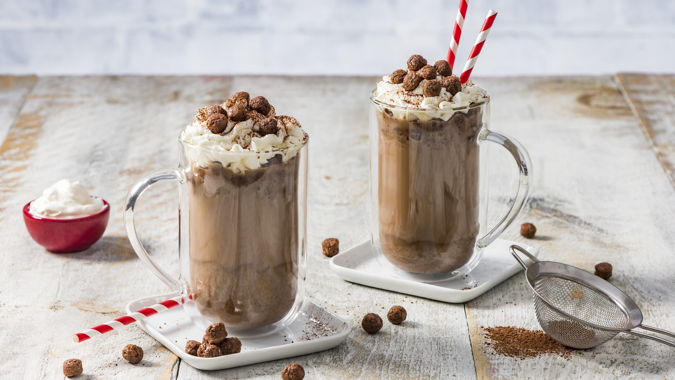 Timbits Chocolate Glazed Iced Latte Frappe in two glass cups on a wooden background.