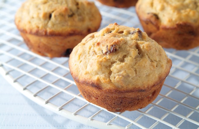 Banana Raisin muffins on a white cooling rack.