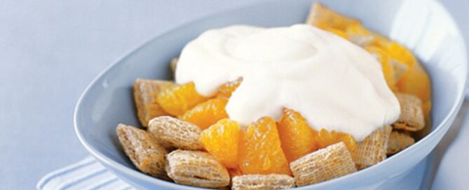Post Shredded Wheat with Yogourt & Fruit in a blue bowl on a blue table.