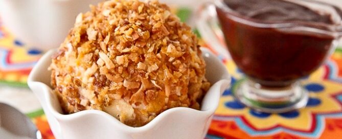 "Fried" Ice Cream with Cinnamon-Chocolate Sauce in a white bowl with chocolate sauce in the background.