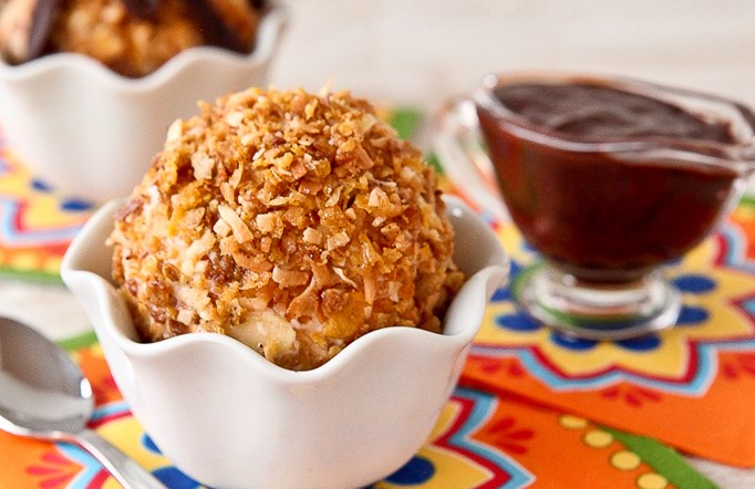 "Fried" Ice Cream with Cinnamon-Chocolate Sauce in a white bowl with chocolate sauce in the background.