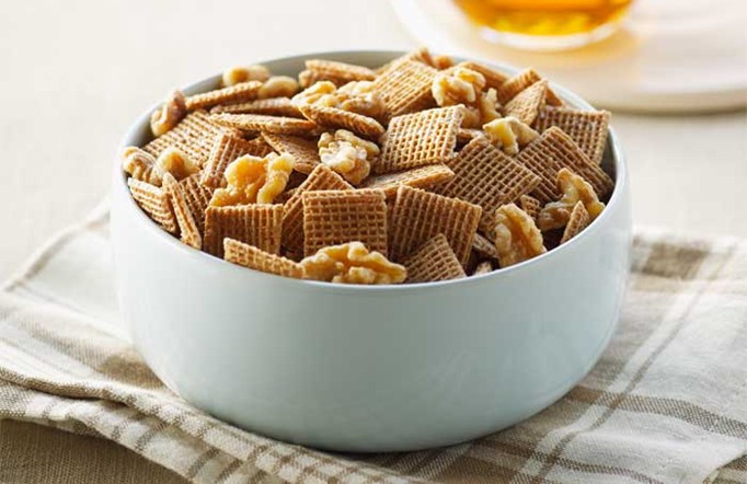 Shreddies Maple Walnut Mix in a blue bowl on a white and brown checkered cloth.