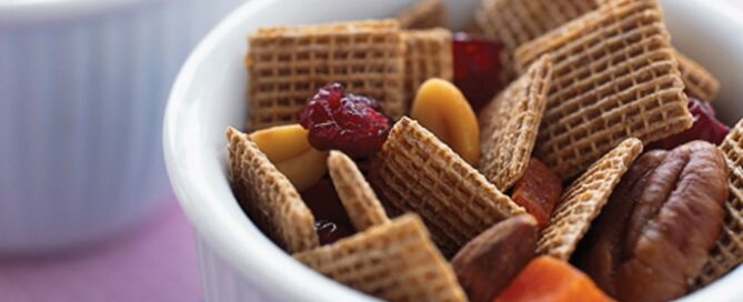 Shreddies Pecan Crunch in a white bowl on a blue and pink table cloth.