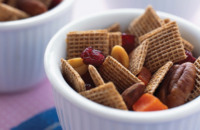 Shreddies Pecan Crunch in a white bowl on a blue and pink table cloth.