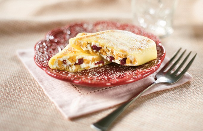 Cranberry Almond Crunch Blintzes on a red plate with a fork on the side.