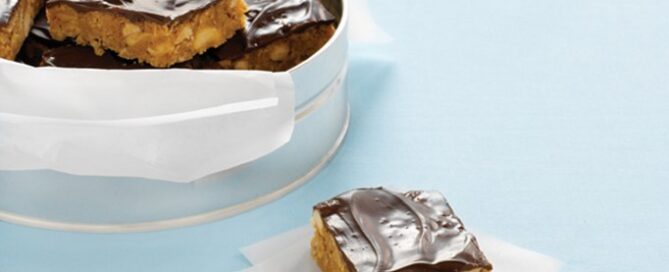 Honey Bunches of Oats Chocolate Crunch Squares sitting on a white napkin on a blue background.