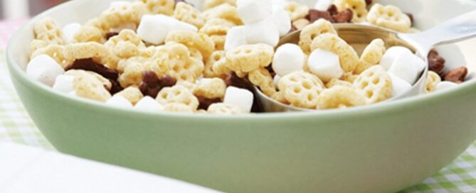 Honeycomb cereal in a green bowl with mini marshmallows and chocolate chips.