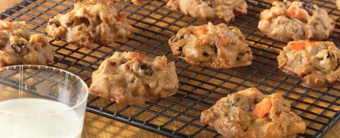Bran Fruit and Nut Cookies on a drying rack with a glass of milk on the side.