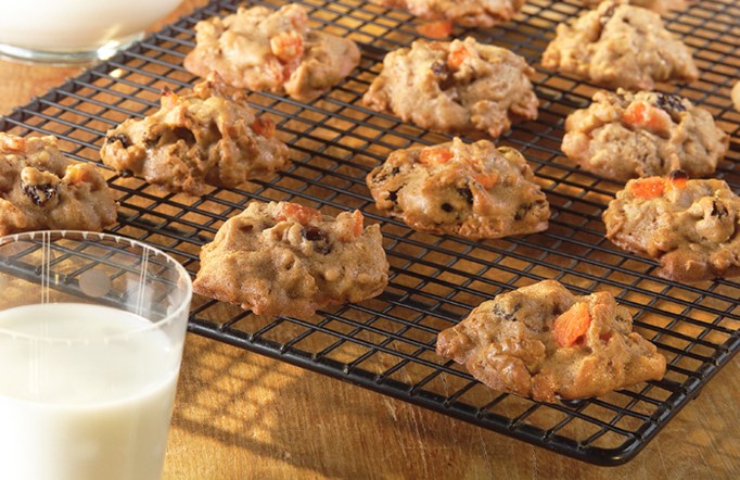 Bran Fruit and Nut Cookies on a drying rack with a glass of milk on the side.