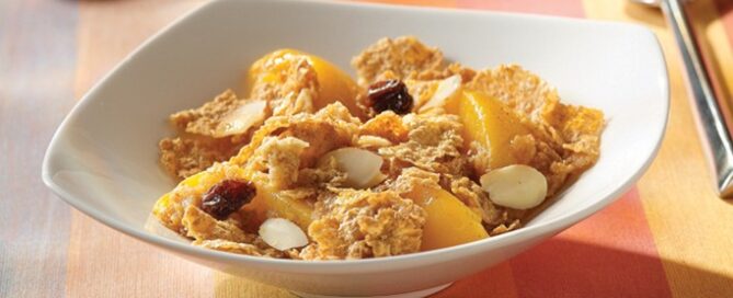 Cranberry Almond Crunch Fruit Crumble in a white bowl with a spoon on the side.