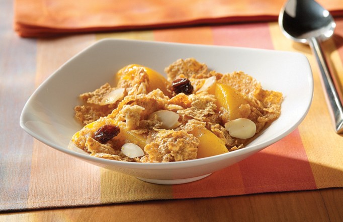 Cranberry Almond Crunch Fruit Crumble in a white bowl with a spoon on the side.