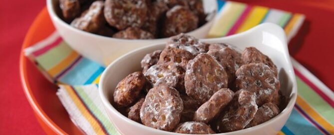 Chocolate covered Honeycomb cereal in two white bowls on colorful napkins.
