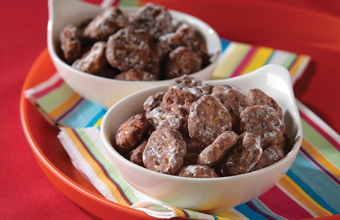 Chocolate covered Honeycomb cereal in two white bowls on colorful napkins.