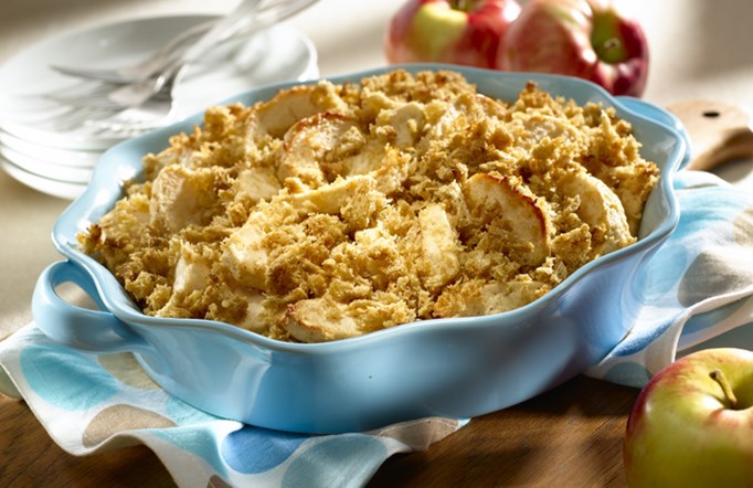 Shredded Wheat Apple Crisp on a wooden table in a blue casserole dish.