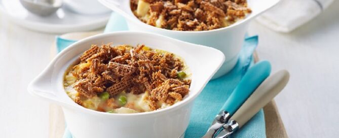 Shreddies Chicken Pot Pies on a blue napkin with two spoons on the side.