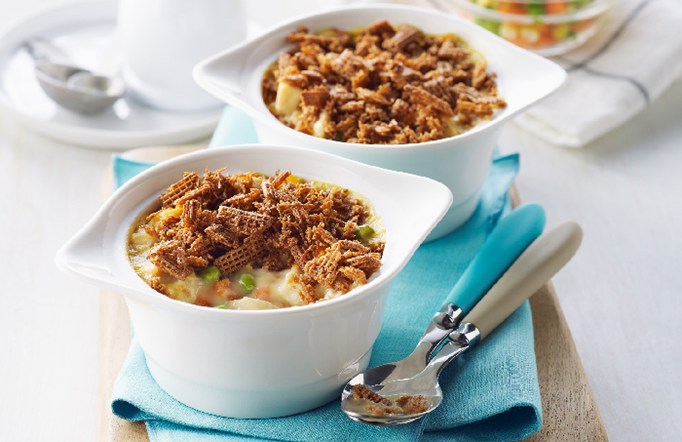 Shreddies Chicken Pot Pies on a blue napkin with two spoons on the side.