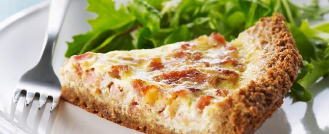 Shreddies Quiche Lorraine on a white plate with lettuce on the side.