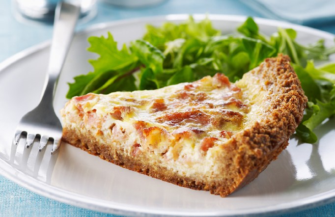 Shreddies Quiche Lorraine on a white plate with lettuce on the side.