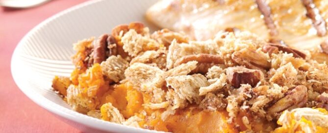 Streusel Baked Winter Squash on a white plate on a pink tablecloth.