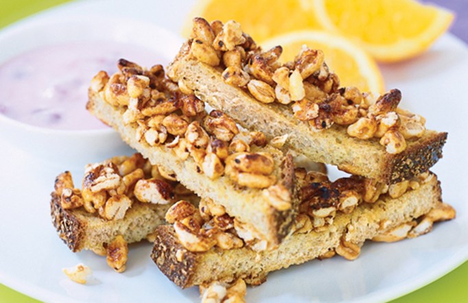 Sugar Crisp French Toast Fingers on a white plate with lemons in the background.