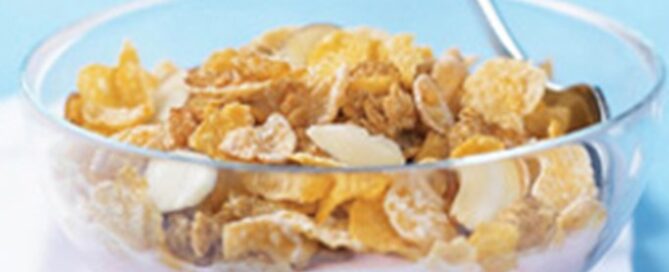 Honey Bunches of Oats and yogurt in a bowl on a blue background.