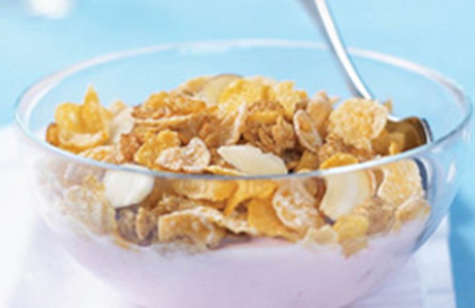 Honey Bunches of Oats and yogurt in a bowl on a blue background.